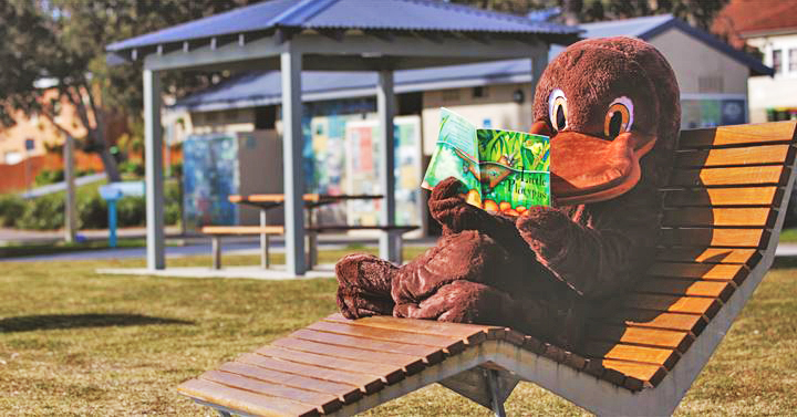 Platypus mascot in deck chair reading